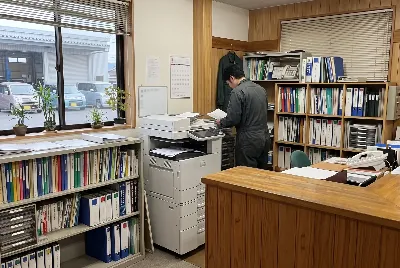 自動車整備工場・販売店の事務所で事務作業をしている様子
