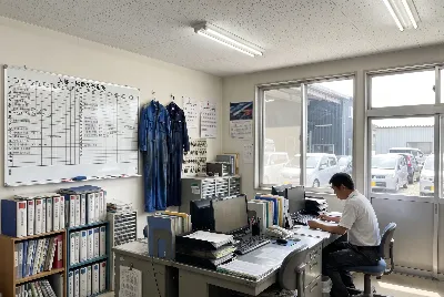 自動車整備工場・販売店の事務所で事務作業をしている様子