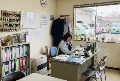 自動車整備工場・販売店の事務所で事務作業をしている様子