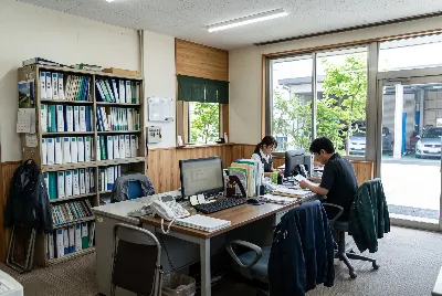 自動車整備工場・販売店の事務所で事務作業をしている様子