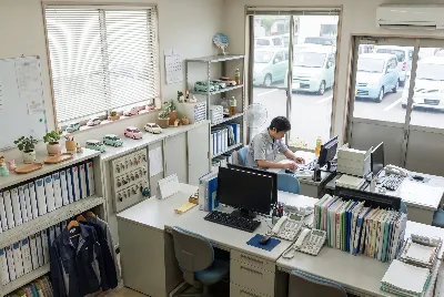自動車整備工場・販売店の事務所で事務作業をしている様子