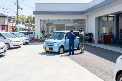 店先で水色の軽ハッチバックを前に商談